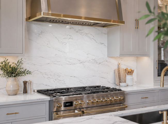 Calacatta quartzite countertop and full-height backsplash with bookmatched movement