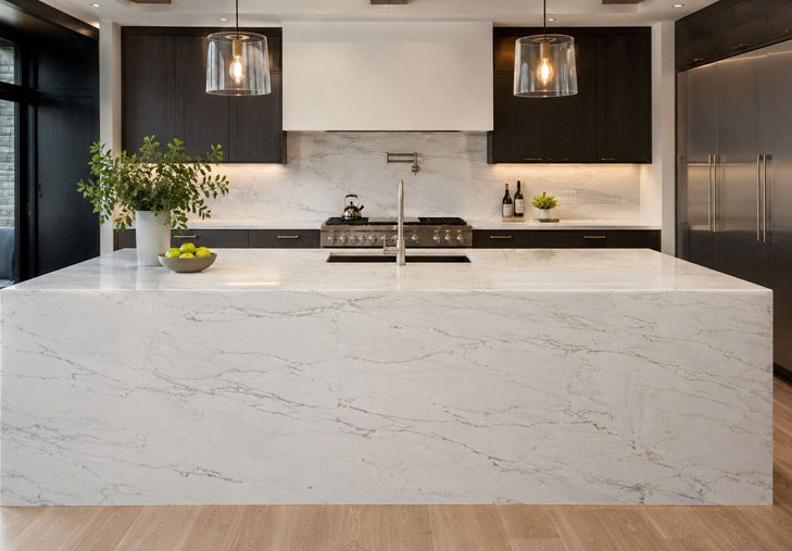 Calacatta quartzite kitchen island with waterfall edge and bright cabinetry
